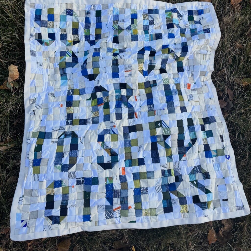 On the ground, a blue green and white pixelated quilt that reads You Were Put on This Earth To Serve Others