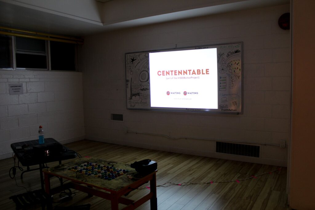 A distance shot of a set up of a game with a projected image that says Centenntable.